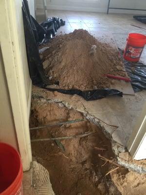 Trench in bedroom for pipe replacement.