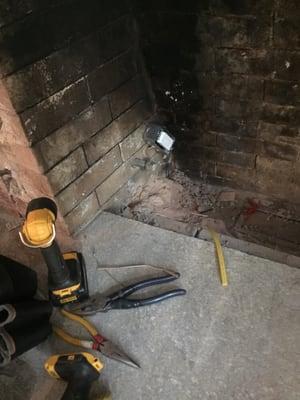 In process of putting outlet in chimney for gas insert fireplace