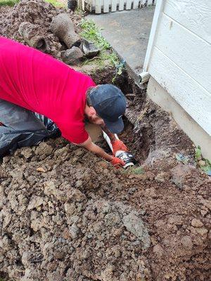 Repairing damaged section of concrete drain line.