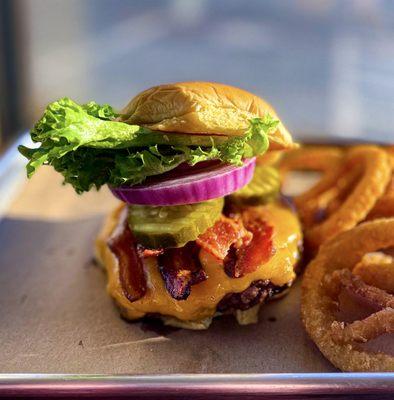 Heaven's bacon cheddar burger with a side of onion rings