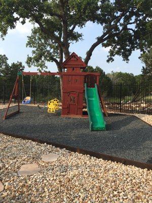 Leveled play set area with rustic metal edging