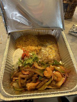 Steak and shrimp fajitas, beans, rice, with guac, lettuce, sour cream, and tomatoes.