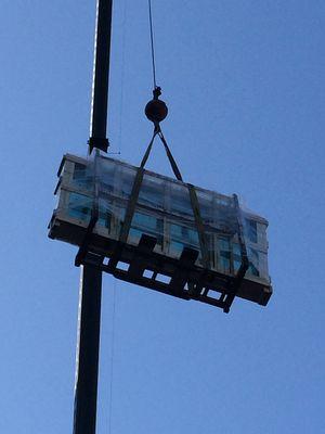 Crane lifting crate of glass