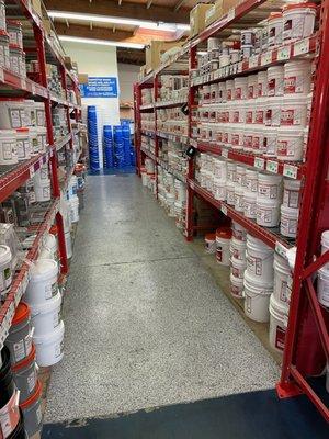 Row of shelves stacked with tubs of carpet cleaning chemical at Jon-Don San Diego