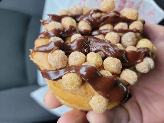 Reese Peanut Butter Puff w/Chocolate Drizzle (Specialty Donut) - Plenty of peanut butter and Reese Puffs and gooey chocolate drizzle!