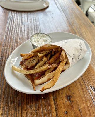 Tilikta chicken thigh pita sandwich with tzatziki sauce on the side