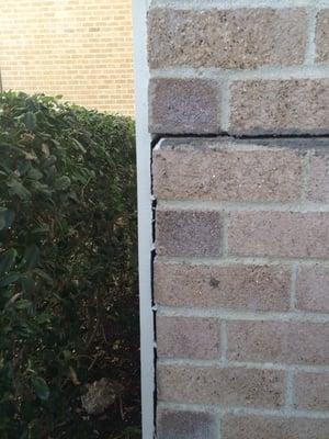 Shift in structure leading to slit in masonry and separation from wood siding