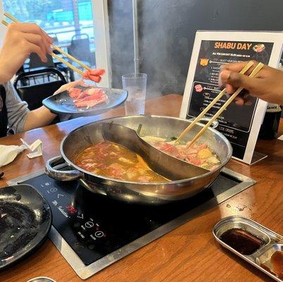 House spicy broth on the left and beef broth on the right.