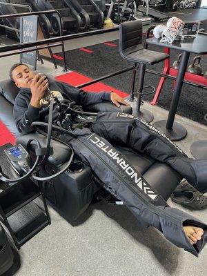 High school football player using compression therapy to prepare for his game