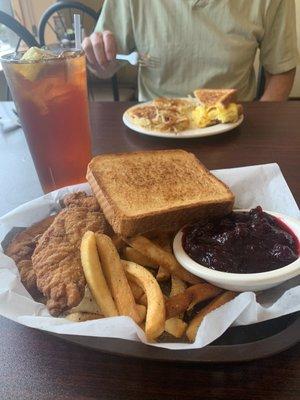 Chicken tender basket; buttered toast; fresh cranberries and French fries.