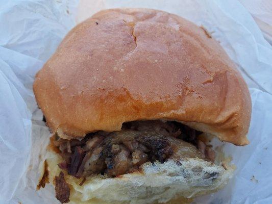 Brisket sandwich with BBQ sauce on a homemade bun.