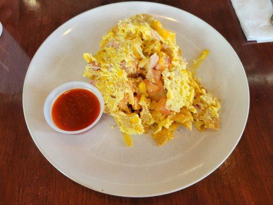 Migas Con Jamon (caramelized onions, tomatoes, roasted corn, jack cheese, ham, scrambled eggs, crispy tortillas, and avocado crema).