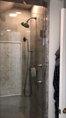 Showing completed shower after plumbing reconfigured, tile and fixtures installed.