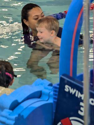 My grandson learning to swim as you can see he has a smile on his face.