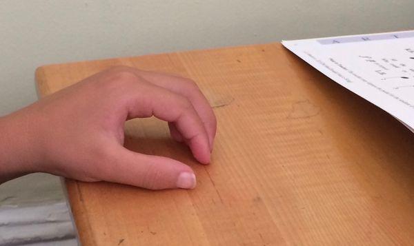 Using rounded fingers to tap out piano pattern on tabletop prepares hand for holding pencil properly