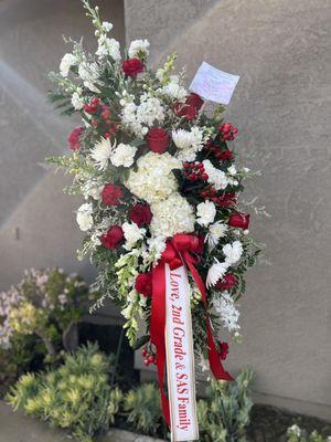 Red and white tribute spray with custom ribbon.