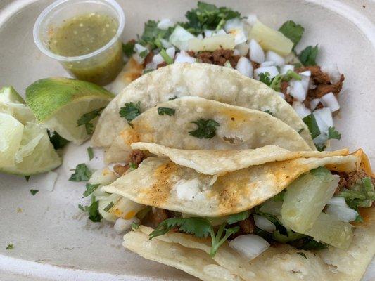 Al pastore tacos with tomatillo salsa and lime wedges