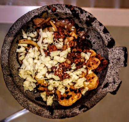 Molcajete served in Lava Rock Bowl has grilled chicken, steak, shrimp and chorizo mixed with vegetables topped with shredded cheese.