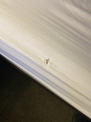 A hole in the sheet that shows there is no mattress cover