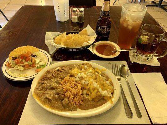 Tex-Mex (2 enchiladas beef and carne guisada) with rice and beans. Added a crispy beef taco. Chips and salsa a negro Modelo and iced tea.