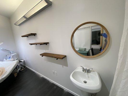 A step up design with pipe-rod floating wood shelves and mirror for a relaxing feel in a spa room.