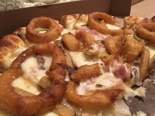 The 420 pizza: onion rings, jalapeño poppers, fries, ham, and a cream sauce.