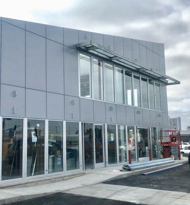 Clear Anodized Aluminum Storefront with Insulated Glass and Narrow Stile Doors. Siding Installation.