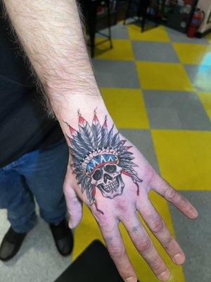 Skull with headdress tattoo on hand