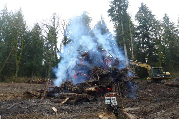 My Excavator tending burn pile and fan on newly cleared land.