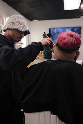 Jeric Austria trimming down a beard while finishing of his a haircut