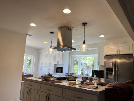 Exhaust and hanging lights over the cooking top island