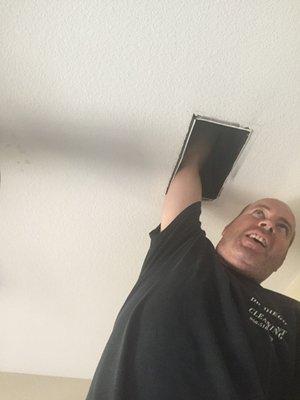 Eric cleaning out an air vent