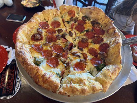 Deep dish pizza, ricotta base, pepperoni, sausage, and spinach.