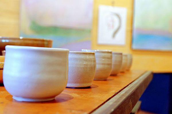 Local hand made pottery, with larger painting on the main gallery wall