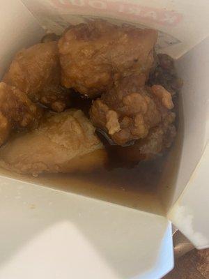 Orange chicken drowning in water.