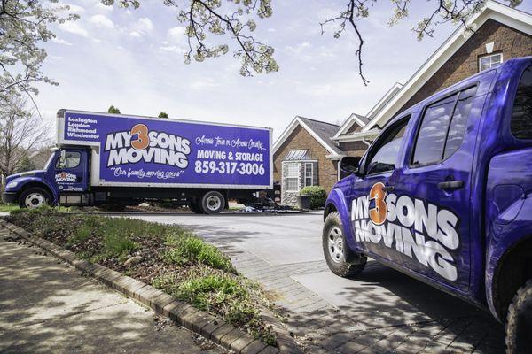 Sunny day with a large, colorful My 3 Sons moving truck parked outside a cozy home. Preparing for a very efficient move!