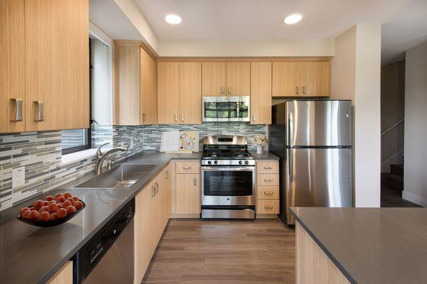 Kitchen with stainless steel appliances, hardwood style flooring, and island.