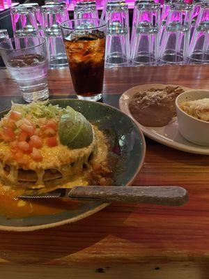 Stacked carnitas enchilada with refried beans and street corn