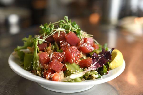 Ahi Poke; Sushi-grade tuna marinated in a soy dressing, over cabbage, mixed greens, bell pepper, daikon sprouts, snow peas & wontons