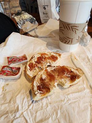 Bagel with cream cheese and strawberry jam and toasted coconut latte