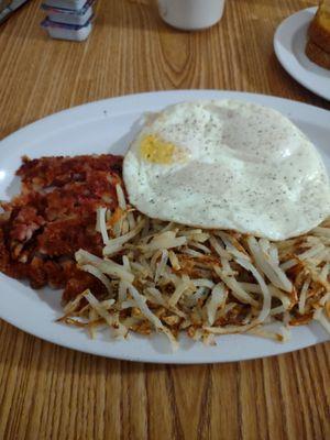 Three eggs hash browns and corned beef hash.