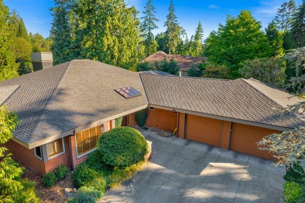 A stunning suburban home featuring a professionally installed asphalt shingle roof with a sleek skylight for added natural lighting.