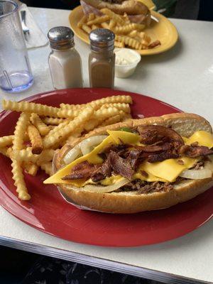 Philly steak sandwich with fries.