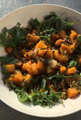 Roasted butternut squash salad with pepitas, a light shallot vinaigrette on baby field greens