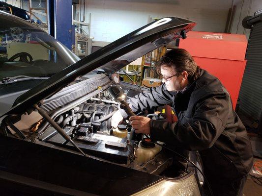 Crist (New Manager from Del Ray neighborhood)repairing car for customer.