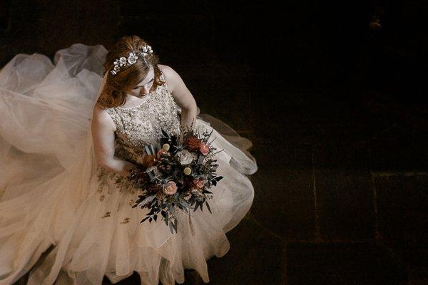 Autumn bride walking down staircase with wedding bouquet in vintage victorian estate, mountains, anomalie wedding dress