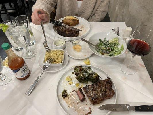 Ribeye w baked potato and iceberg lettuce salad   New York Strip with brussel sprouts and grits