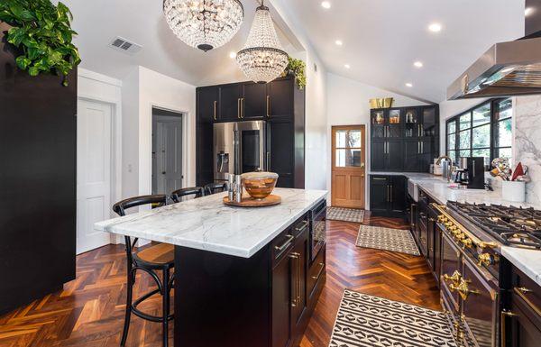 Transitional Kitchen Remodeling Project with brass handles, dark shaker style cabinets and marble counters.