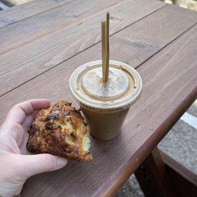 Oat milk latte with bamboo straws and a cheddar scallion scone