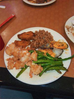 Coconut shrimp muscles, fried rice, green beans, and chicken wings